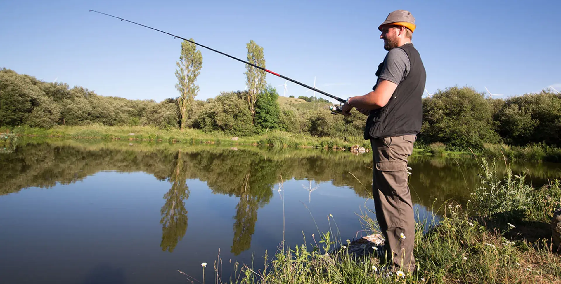 Pêcheur en face d'un plan d'eau