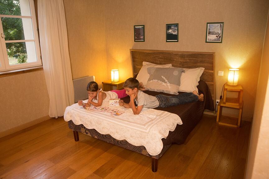 Deux enfants allongés sur un lit, jouant à un jeu de société