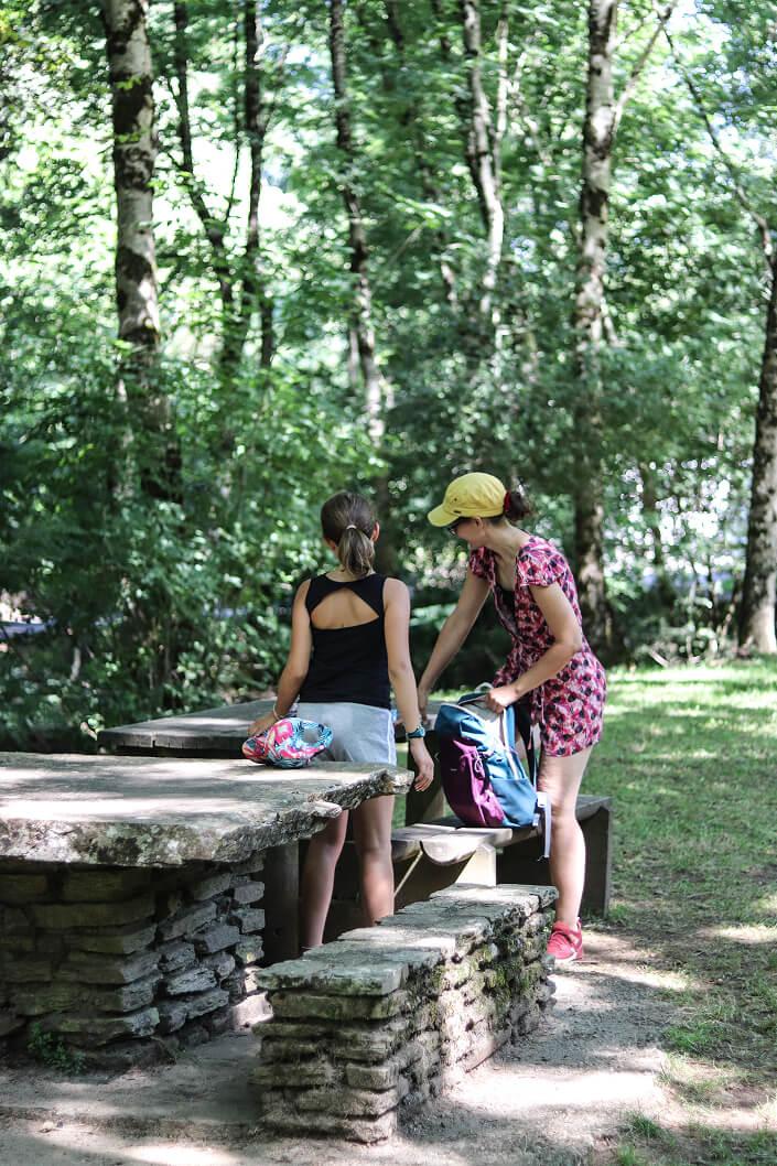 Personnes assisent à une table de pique-nique en pierre