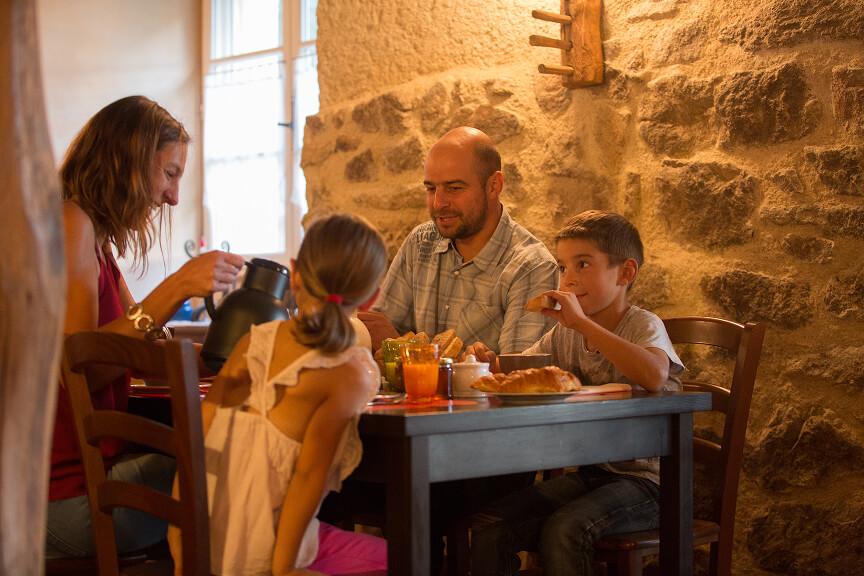 2 adultes et 2 enfants assient à une table d'un restaurant 
